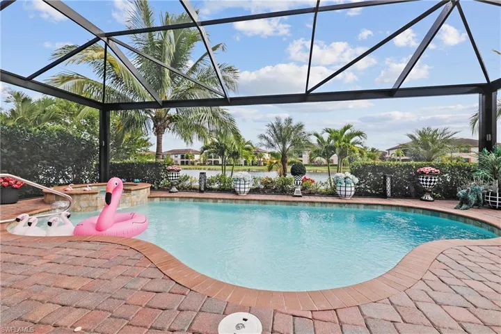 View of swimming pool featuring a lanai, a sunroom, and a pool with connected hot tub