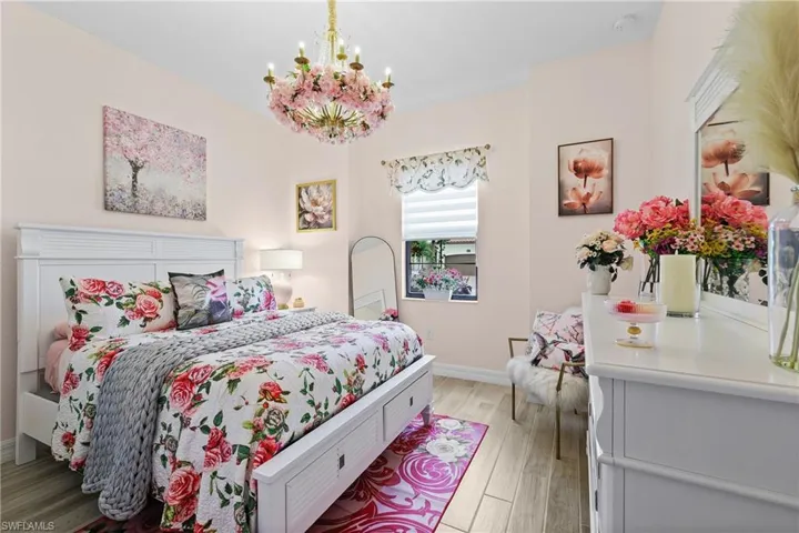 Bedroom with light tille finished floors and a chandelier