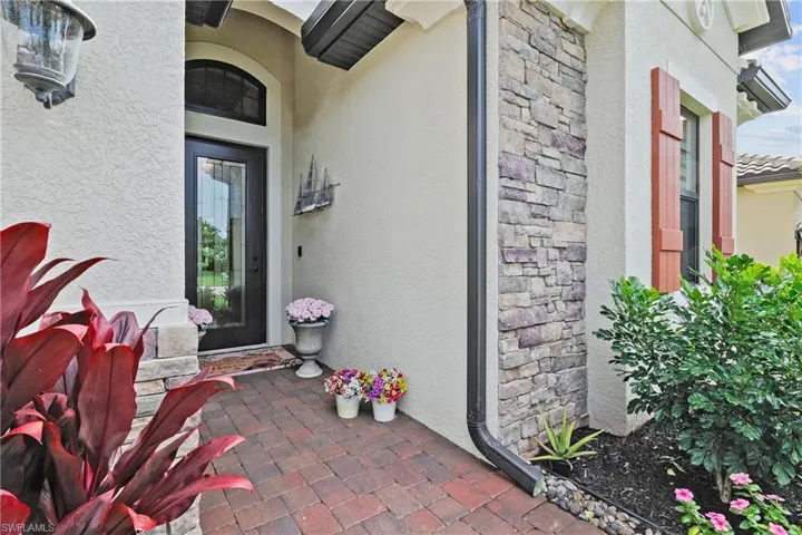 Property entrance with stone siding and stucco siding