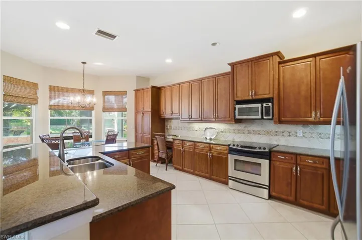 Custom cabinetry, crown molding, granite countertops with beveled edges, a fully upgraded stainless steel appliance package, and tumbled marble backsplash with decorative inlays!