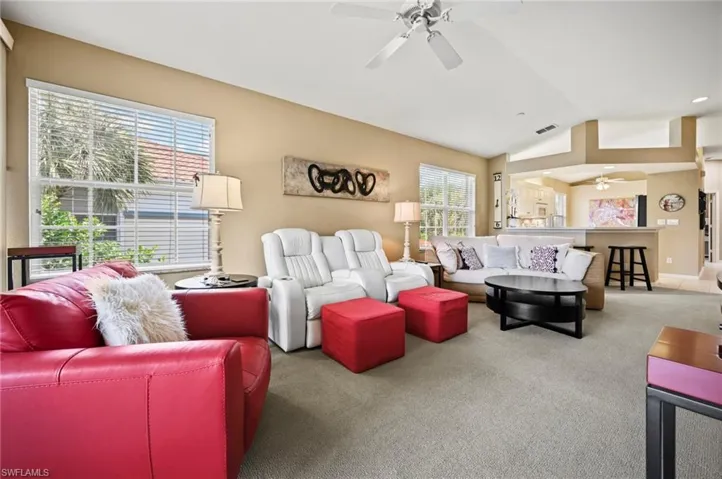 Living room with a wealth of natural light, vaulted ceiling, and ceiling fan