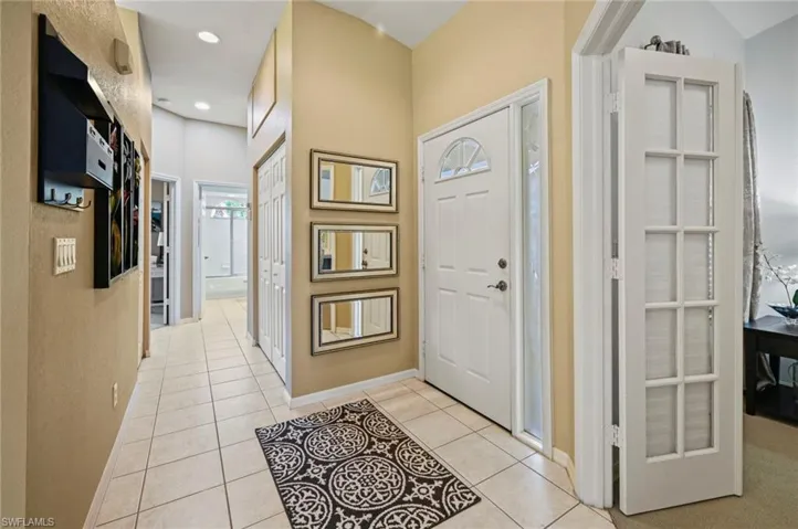 Foyer with light tile patterned flooring