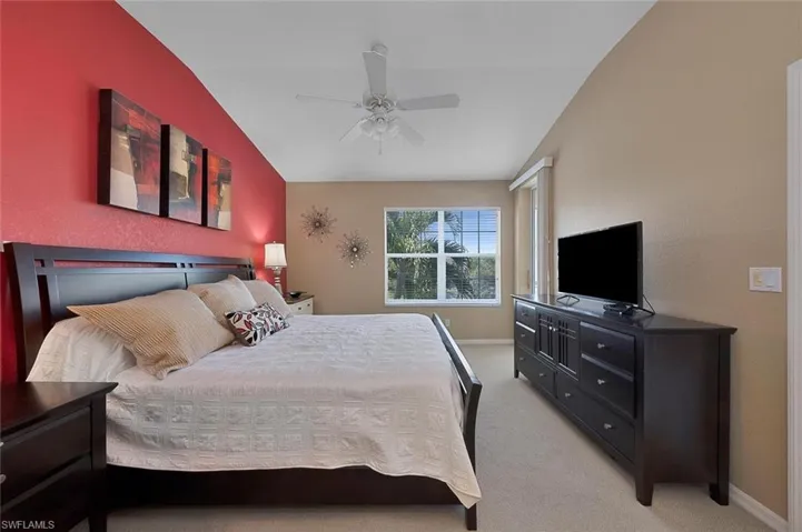 Bedroom with carpet, vaulted ceiling, and ceiling fan