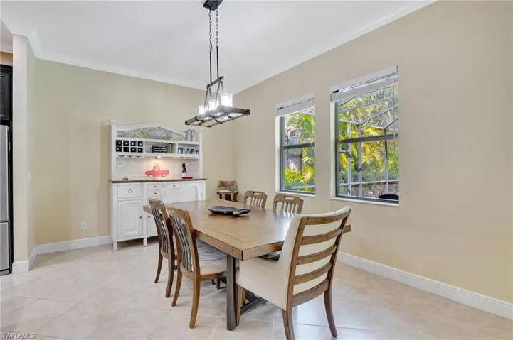 Dining space with baseboards, light tile patterned floors, and crown molding