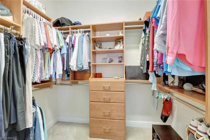 Walk in closet featuring light colored carpet