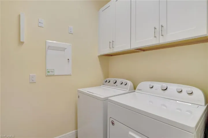 Washroom with cabinet space, washing machine and dryer, and baseboards