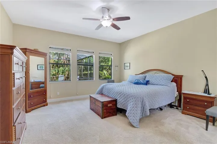 Bedroom featuring light carpet, baseboards, and a ceiling fan