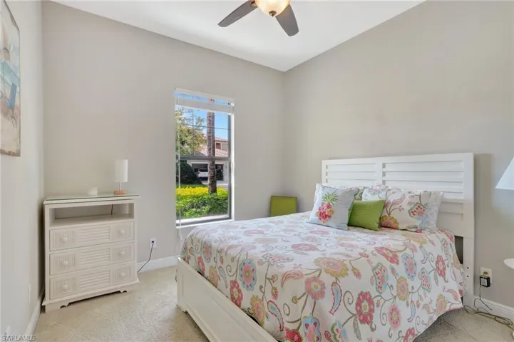 Bedroom featuring baseboards, ceiling fan, and light colored carpet