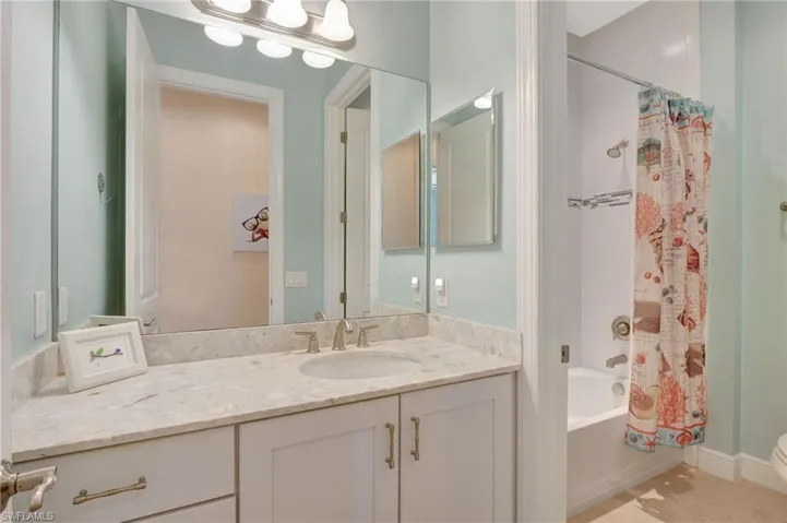 Full bathroom with toilet, tile patterned flooring, vanity, and shower / tub combo with curtain