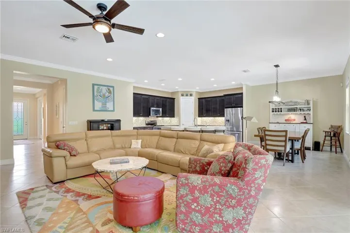 Living room featuring recessed lighting, visible vents, crown molding, and light tile patterned flooring