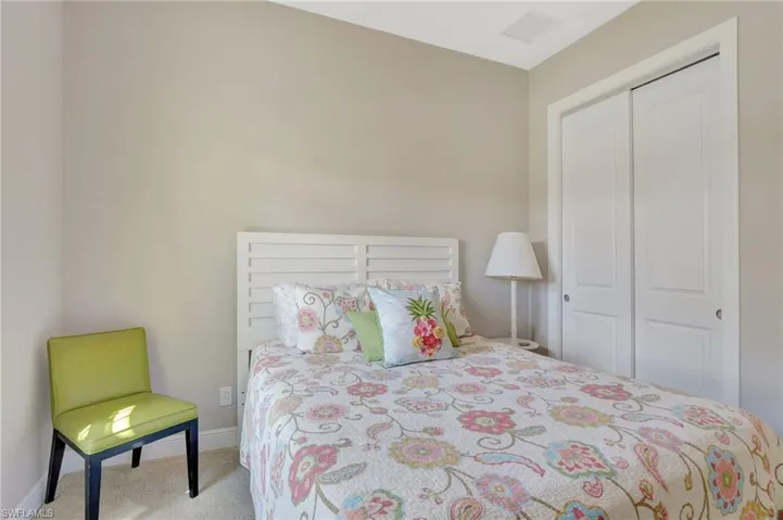 Bedroom featuring baseboards, visible vents, a closet, and light colored carpet