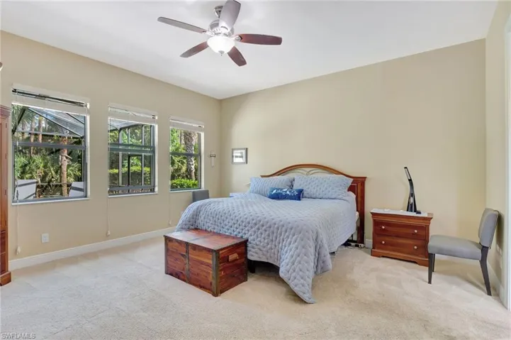Bedroom with light carpet, ceiling fan, and baseboards