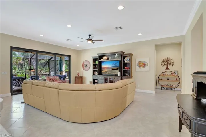 Living room featuring baseboards, visible vents, crown molding, and recessed lighting