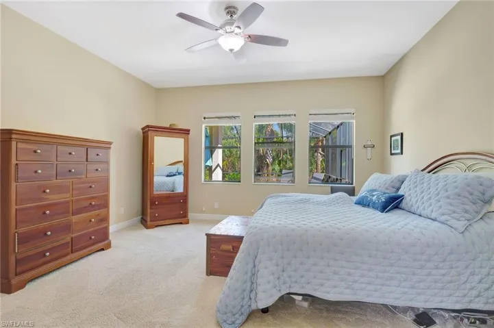 Bedroom featuring ceiling fan, baseboards, and light colored carpet