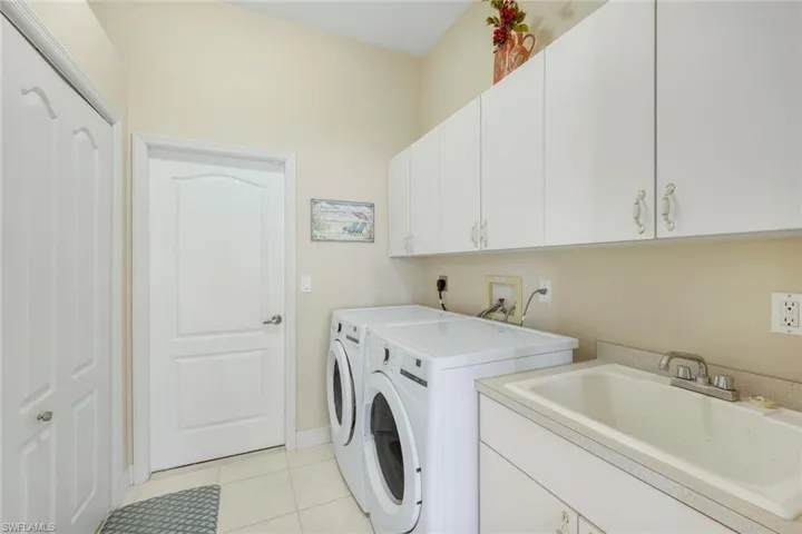 Laundry room with extra storage, newer washer/dryer, laundry sink & extra cabinets