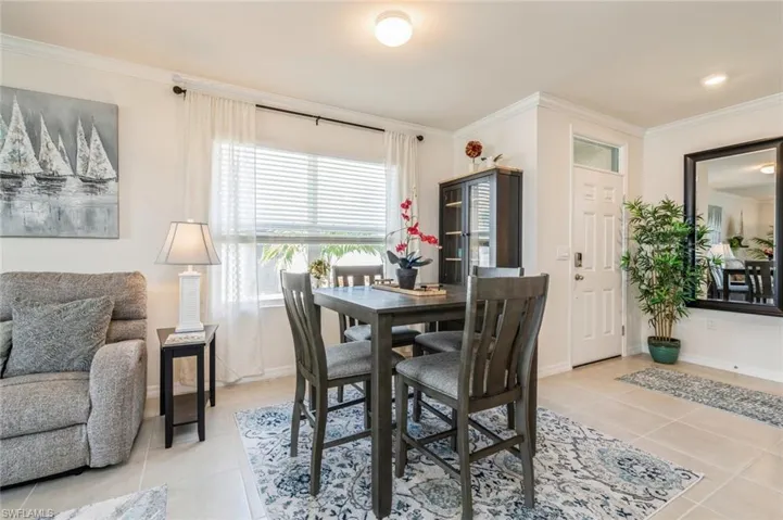 Dining area featuring light tile patterned flooring and crown molding
