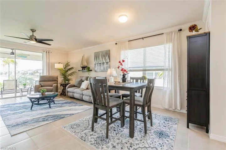Dining area featuring ceiling fan, light tile patterned floors, and ornamental molding