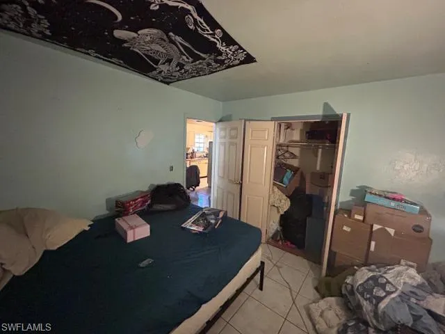 Bedroom with a closet and light tile patterned floors