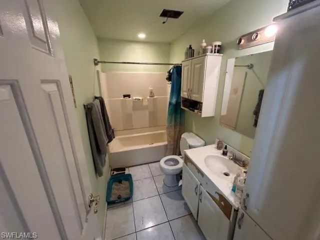 Full bathroom featuring tile patterned floors, shower / tub combo, vanity, and toilet