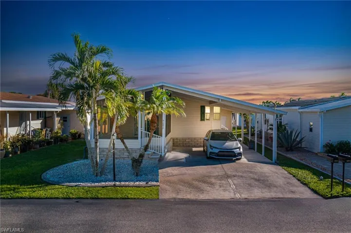 View of front of home with a lawn and a carport
