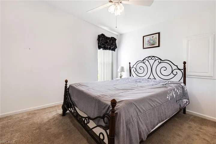 Bedroom featuring dark carpet and ceiling fan