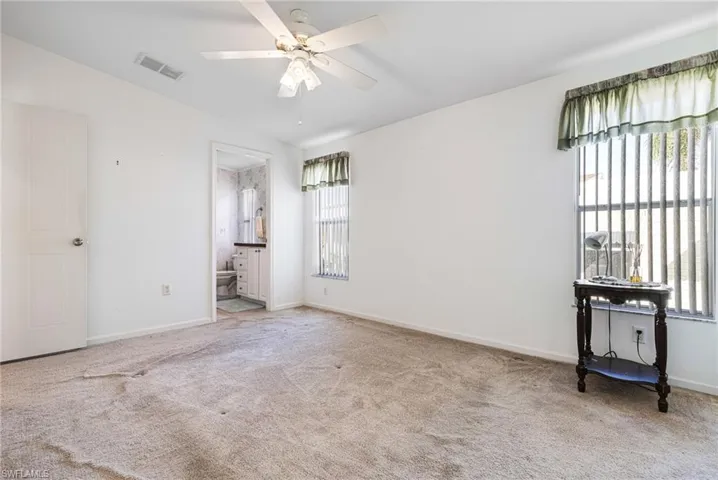 Empty room with ceiling fan and light carpet