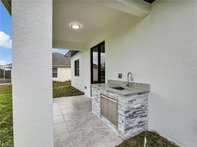 View of patio with an outdoor kitchen and a sink