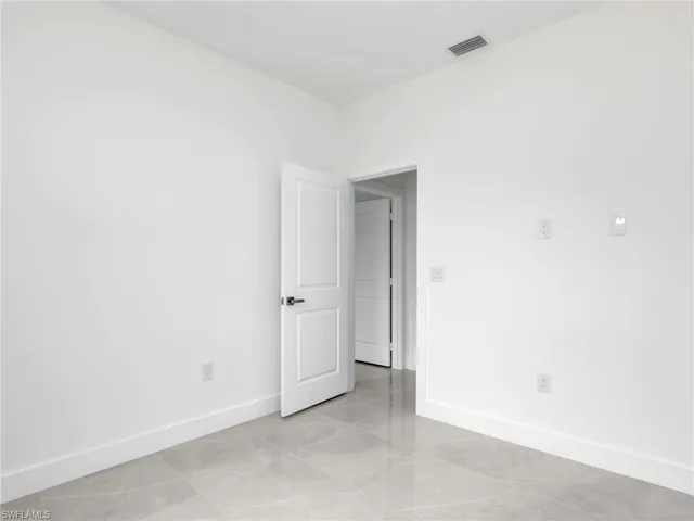 Unfurnished room featuring visible vents and baseboards