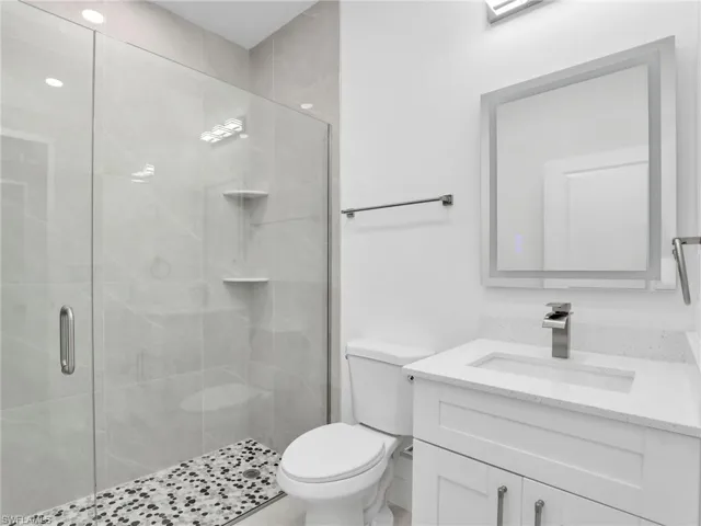 Bathroom with vanity, toilet, and a shower stall
