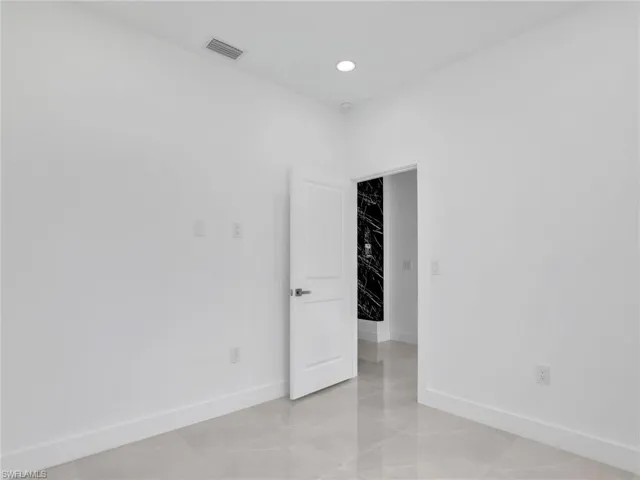 Empty room featuring recessed lighting, visible vents, and baseboards