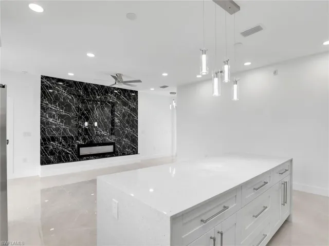 Kitchen with visible vents, light stone countertops, pendant lighting, recessed lighting, and white cabinetry