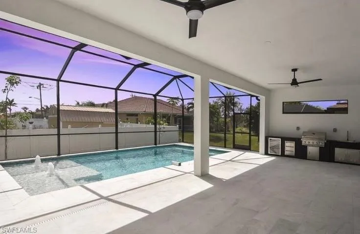 Outdoor pool featuring ceiling fan, a lanai, a sunroom, a patio area, and exterior kitchen