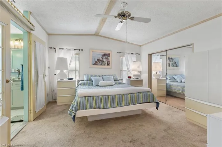 Bedroom with multiple windows, a textured ceiling, and light colored carpet