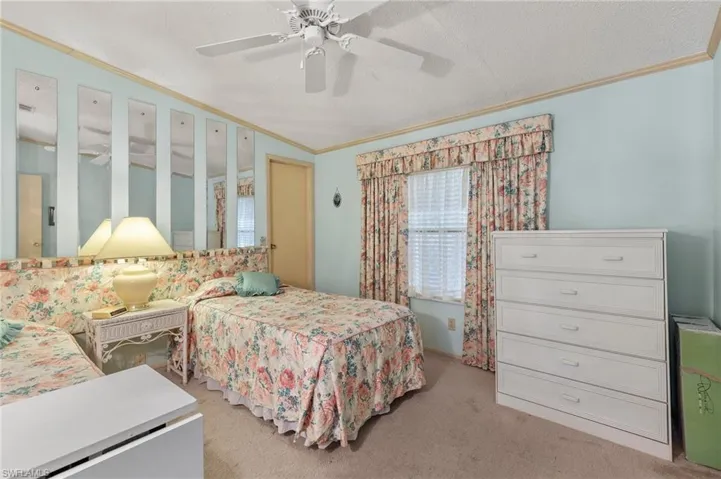 Bedroom featuring ornamental molding, light carpet, ceiling fan, and visible vents
