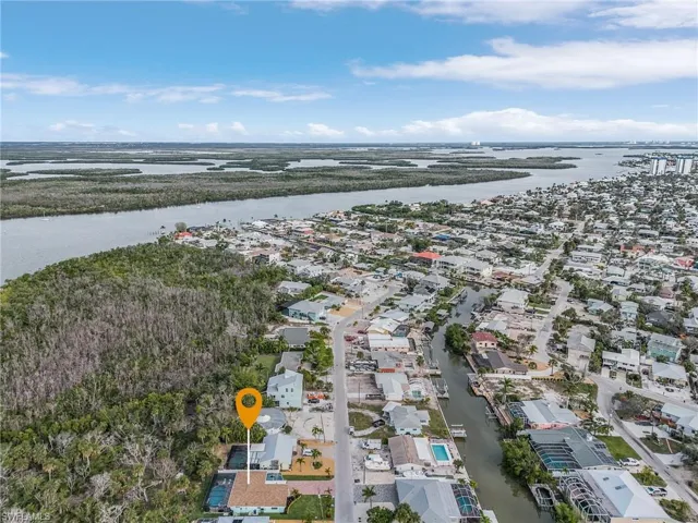 Aerial view of property and surrounding area featuring a nearby body of water and nearby suburban area
