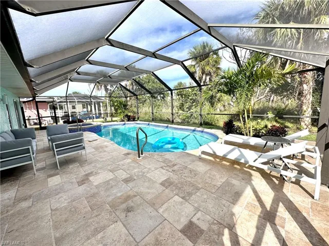 View of pool with a sunroom, a patio, a lanai, and a pool with connected hot tub