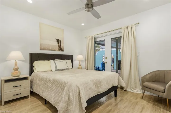 Bedroom with french doors, access to outside, wood tiled floors, recessed lighting, and ceiling fan