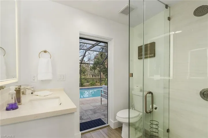 Bathroom featuring a stall shower, vanity, and light wood-style flooring