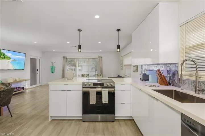 Kitchen with a peninsula, white cabinetry, appliances with stainless steel finishes, modern cabinets, and recessed lighting