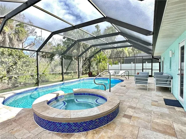 View of pool with a sunroom, a patio area, a lanai, and a pool with connected hot tub