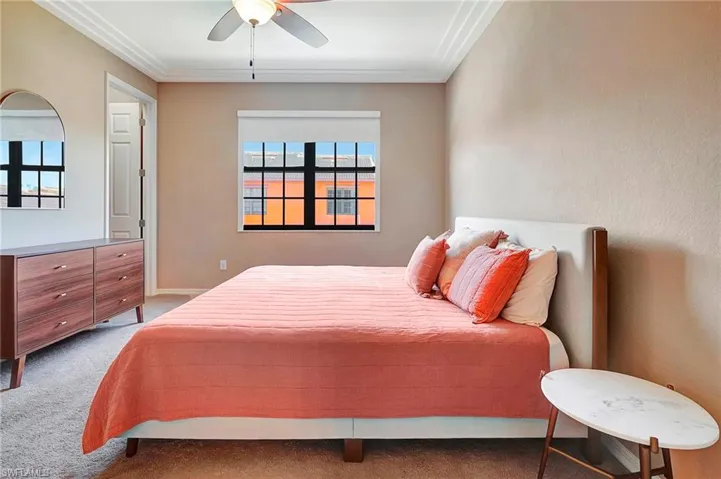 Bedroom with carpet, multiple windows, ornamental molding, and a ceiling fan