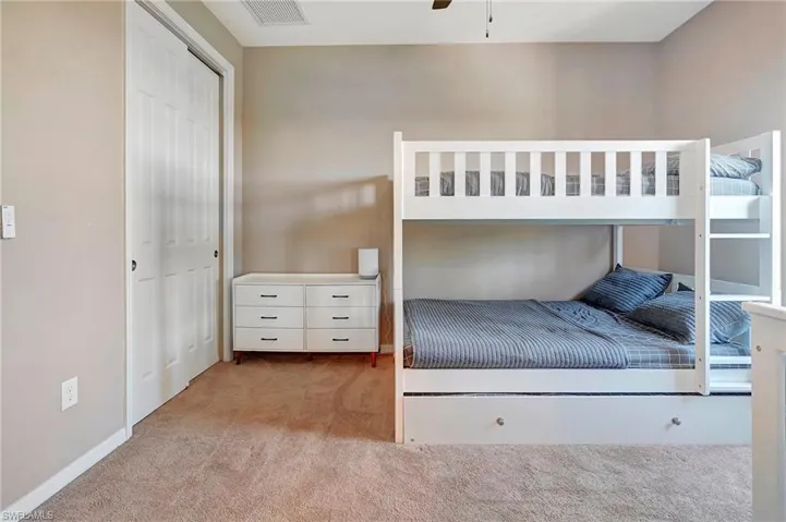 Carpeted bedroom with a closet and baseboards