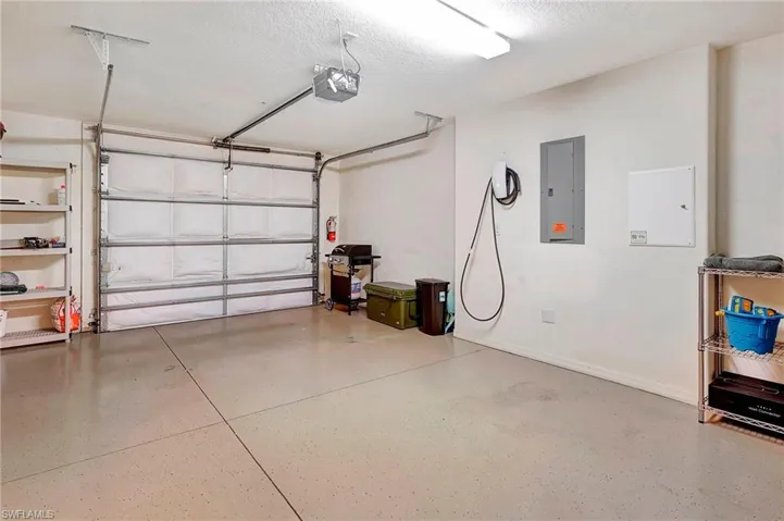 Garage featuring electric panel and a garage door opener