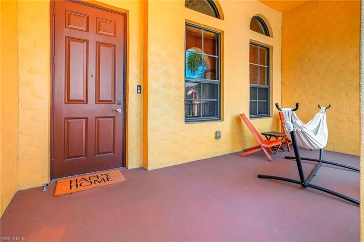 Property entrance with a porch and stucco siding