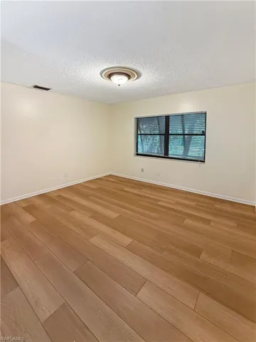 Unfurnished room featuring a textured ceiling and wood finished floors