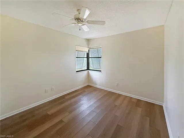 Unfurnished room featuring wood finished floors, a textured ceiling, and a ceiling fan
