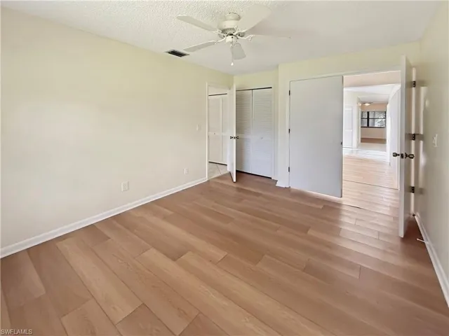 Unfurnished bedroom featuring light wood-style floors, a textured ceiling, and a ceiling fan