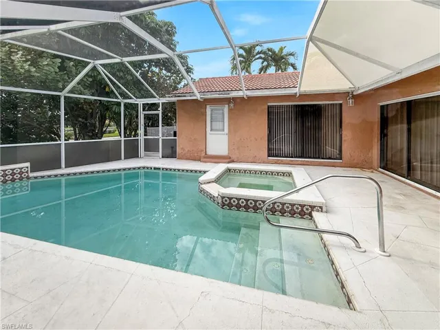 View of swimming pool featuring a patio area, a sunroom, a lanai, and a pool with connected hot tub