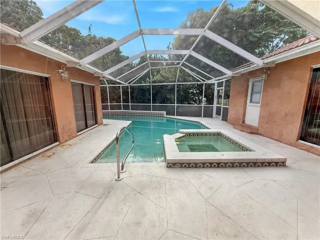 View of pool with a patio, a sunroom, a lanai, and a pool with connected hot tub