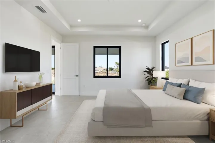Bedroom with a raised ceiling, recessed lighting, and light floors